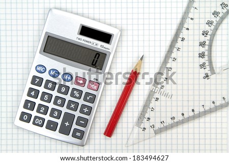 Calculator, lead pencil and ruler on squared paper.