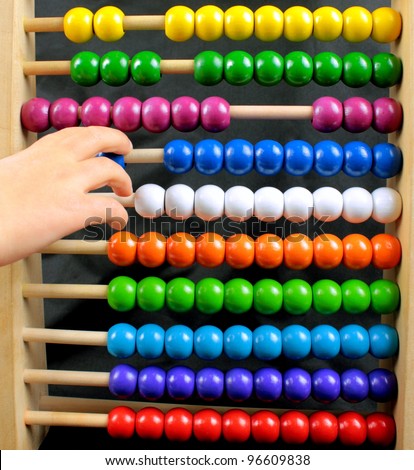 Abacus with many colorful beads and child\'s hand