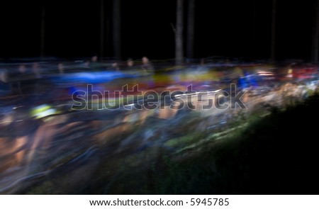 mountain bike race at night with all of the riders making light trails