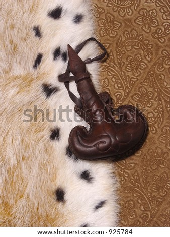 Flask from a leather on a background of imprinted suede and fur