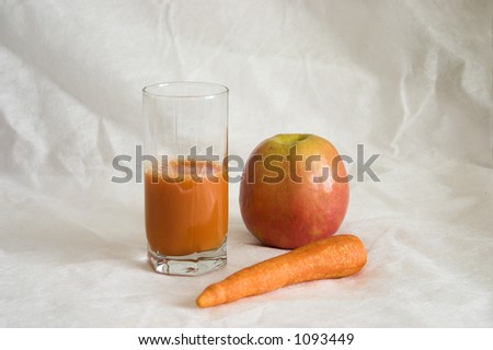 Carrots juice in a glass. An apple and carrots.