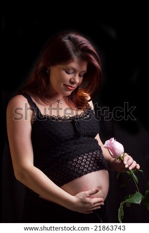 The pregnant red-haired woman of middle age in an evening dress