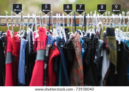 Clothes hanger with clothes of various sizes on clothes rail