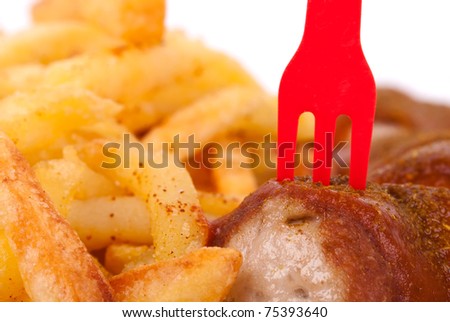 Curried sausage with chips and a red fork