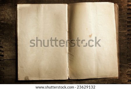 old aged open book with blank pages sitting on antiqued wood