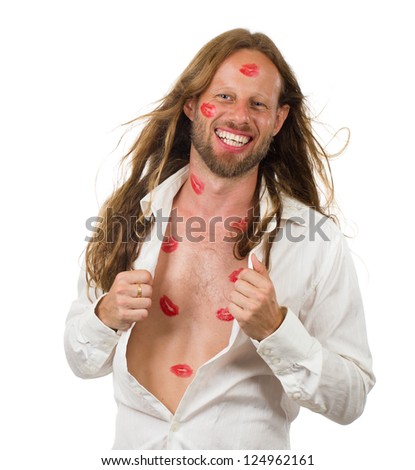 Happy, smiling handsome man covered in red lipstick kisses with his white shirt open