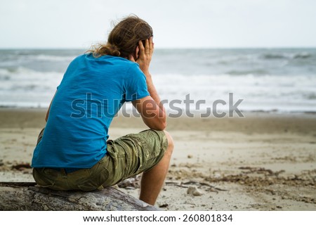 Sad and depressed man alone at the beach
