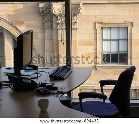view of office desk and sandstone building outside
