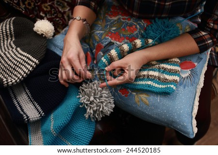 hand of a woman who crochet beanie warm of colored wool