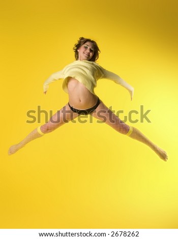 Happy young model jumping high on yellow