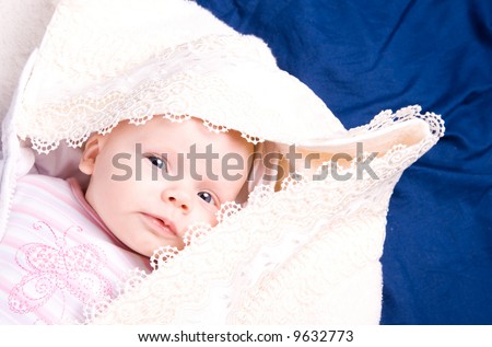 Pretty toddler under a blanket