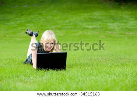 Beauty lady using a notebook computer in a park, shallow DOF and lots of copyspace