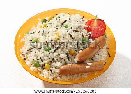 Rice garnish / a portion of cooked black and white rice served with green peas, maize, tomato and sausage in an orange plate
