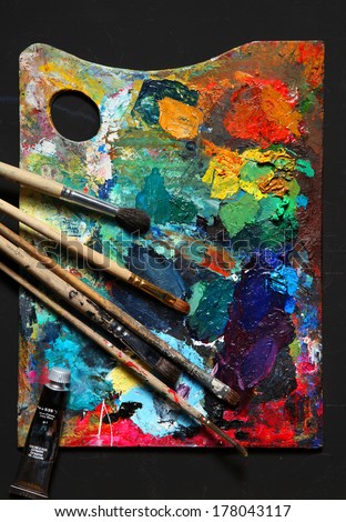 Painting brushes and palette / studio photography of paint utensils on black background