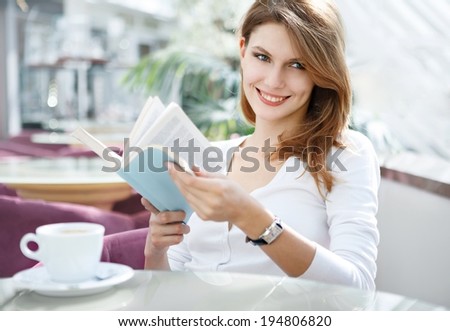 Really interesting book / photo of beautiful woman sitting in a cafÃ?Â© with a book