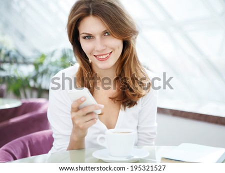 Dial a phone number / photo of beautiful woman sitting in a coffee house