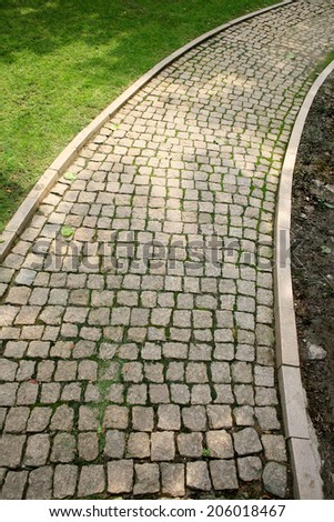 Paved road / outdoors photography of cobblestone sidewalk made of cubic stones
