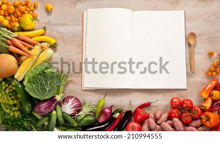 Purchase list. Shopping List. Cookbook. Cookery book. Copy space / food photography of open blank notebook surrounded by a fresh vegetables on wooden table