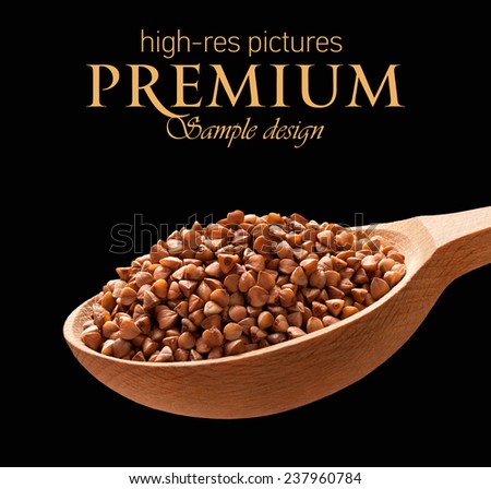 Roasted buckwheat in a wooden spoon / cereal on wooden spoons isolated on black background with place for your text