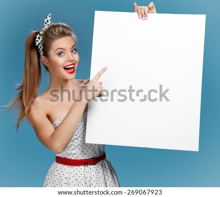 Beautiful pinup girl shows forefinger on the blank banner / photo set of young American pin-up model on blue background with space for text
