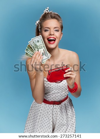 Excited young woman with dollars in her hands. Shopping concept / photo set of young American pin-up model on blue background