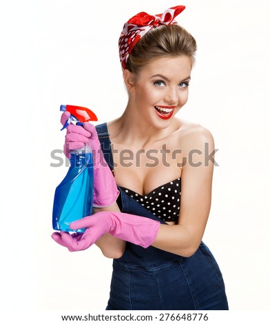 Smiling cleaning woman wearing pink rubber protective gloves holding blue spray / young beautiful American pin-up girl isolated on white background. Cleaning service concept