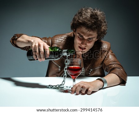 Young man with bottle of alcohol / photo of youth addicted to alcohol, alcoholism concept, social problem