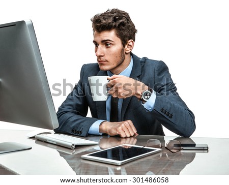 Young office clerk having a coffee time in office sitting at the table / photos of modern businessman at the workplace