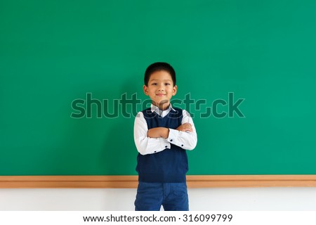 Friendly young asian school boy with his arms folded / photo of teen school Chinese boy, creative concept with Back to school theme