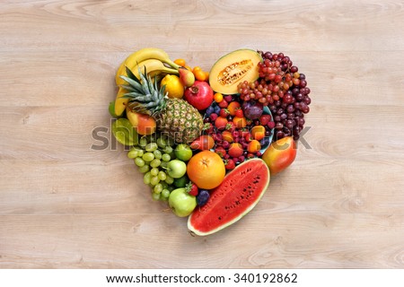Heart symbol. Fruits diet concept. Healthy eating concept / food photography of heart made from different fruits on wooden table. High resolution product.