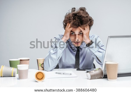 Unfortunate manager dissatisfied with his work. Modern businessman at the workplace working with computer, depression and crisis concept