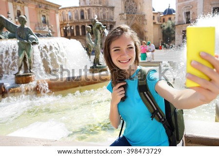 Woman tourist taking selfie pictures on Europe travel. Happy candid tourist on Valencia, Spain. Travel and tourism concept.