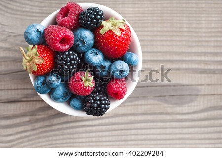 Ripe sweet different berries in bowl. Close up, top view, high resolution product. Harvest Concept