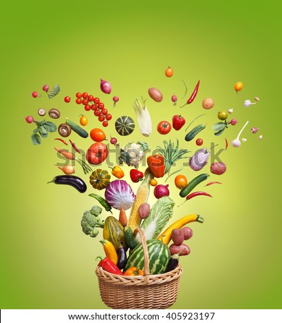Healthy food in basket. Studio photography of different fruits and vegetables on green background, top view. High resolution product.