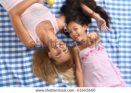 Little Asian beautiful girl in South cruise style lying at the cloth with her mother. They are dreaming about future.