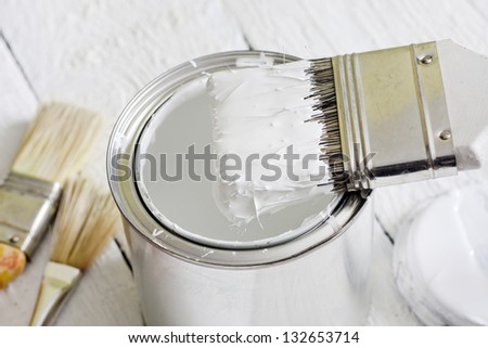 Paint brush and can on white planks