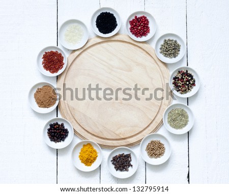 Spices and dried vegetables with cutting board on white planks