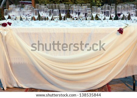 Wedding table outside with empty glasses of champagne after party