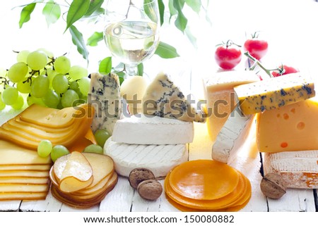 Many types of cheese on cutting board abstract composition