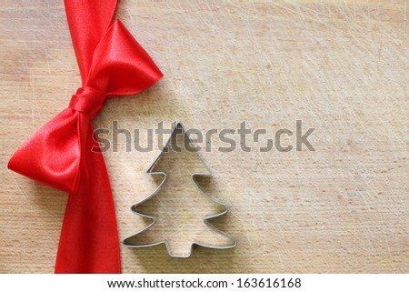 Red ribbon and bow on vintage cutting board christmas background