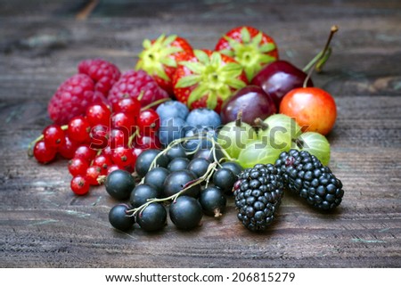 Summer wild berry fruits on vintage board still life concept