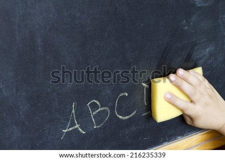 Child\'s hand cleans letters abc education background concept