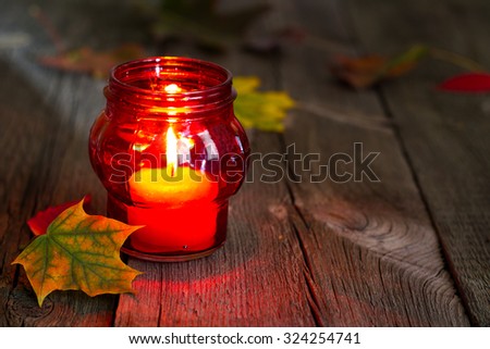 Cemetery red lantern candle with autumn leaves in night