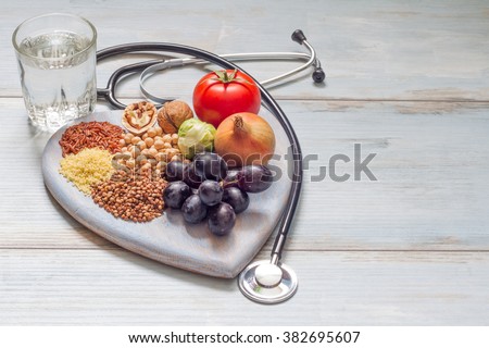 Healthy lifestyle and healthcare concept with food, heart and stethoscope