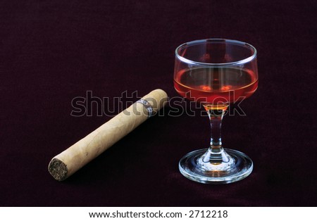 Shot of liquor and cigar on velvet background.