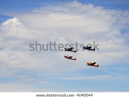 Four small planes are flying in formation on airshow.
