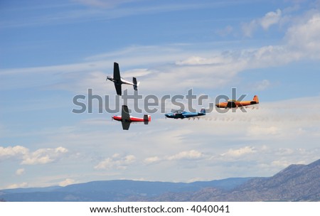 Four small planes are flying in formation on airshow.