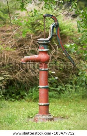 Old and rusty cast iron water well hand pump