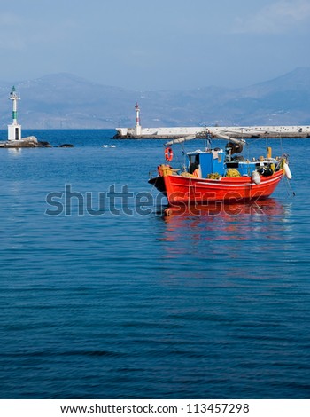 Red fishing boat moored at sea. Mykonos Greece.