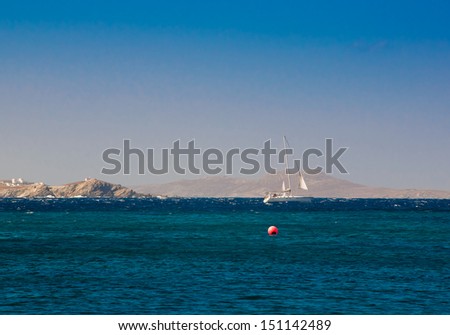 Small yacht in the blue sea off the coast